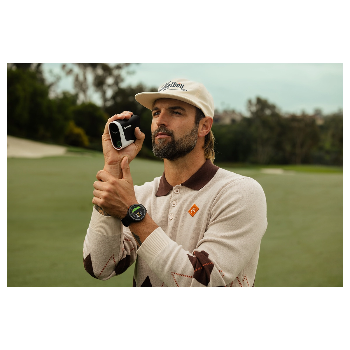 Male golfer using Garmin Approach Z30 laser rangefinder to take measurements on the green