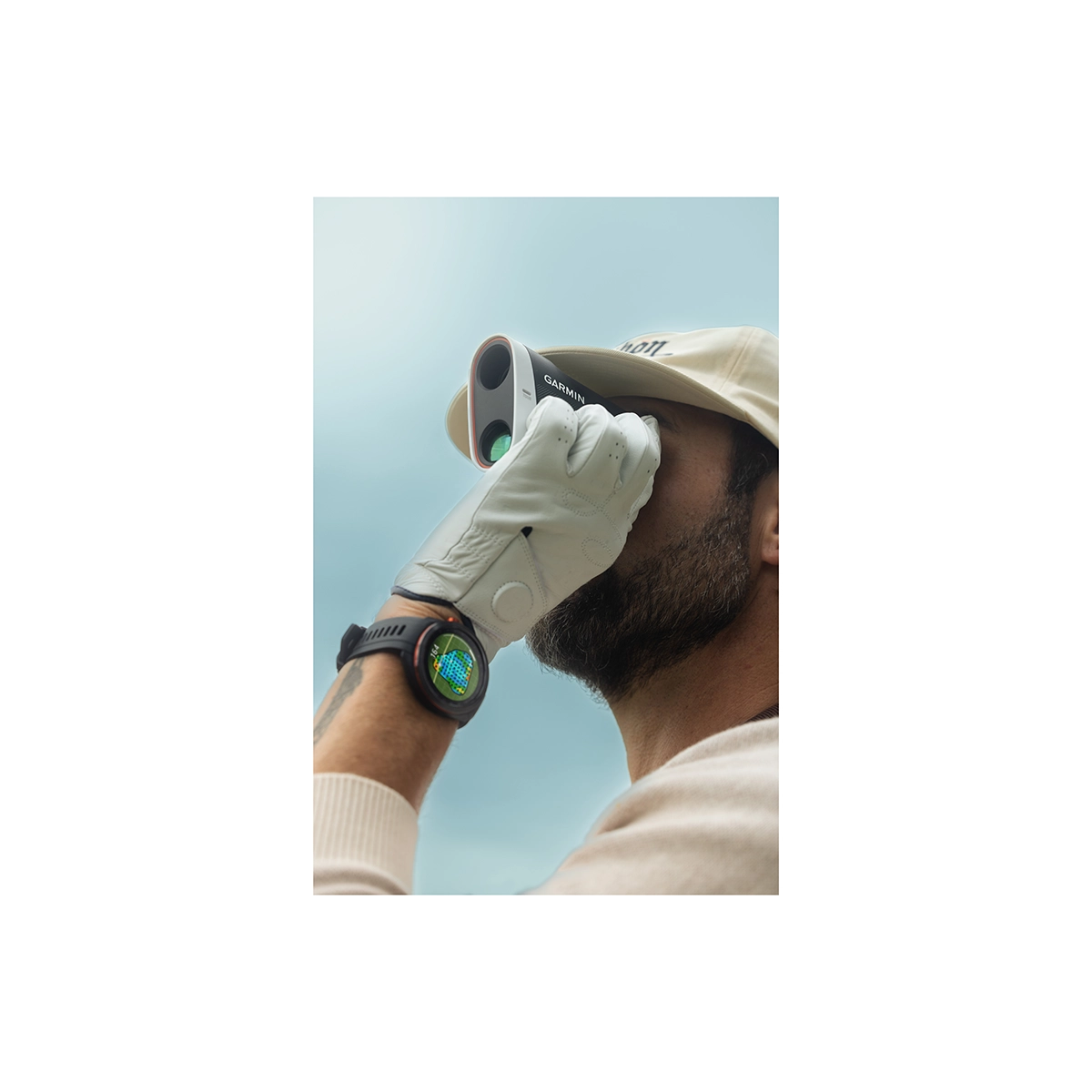 Man using Garmin Approach Z30 golf rangefinder with a Garmin golf smartwatch