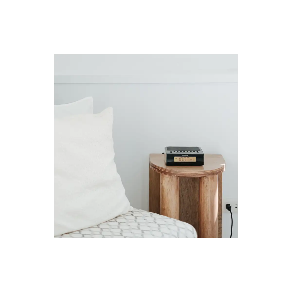 Sangean RCR-5 AM/FM Digital Tuning Radio in black on sidetable plugged into wall